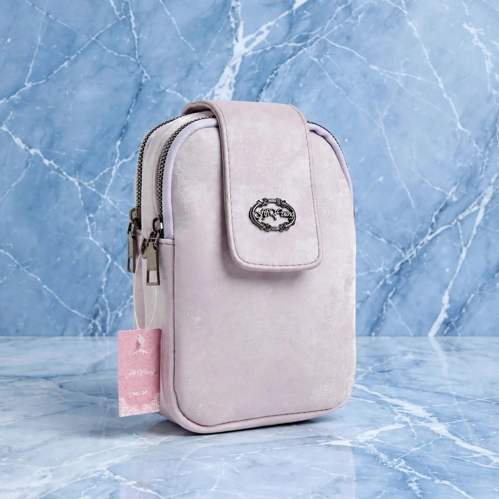 Lavender pink mini mobile pouch bag with front flap, metal logo plate and double zip compartments, side view